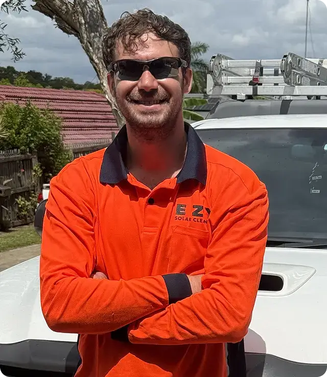 EZY Solar Cleaning team member standing in front of a service vehicle wearing company uniform