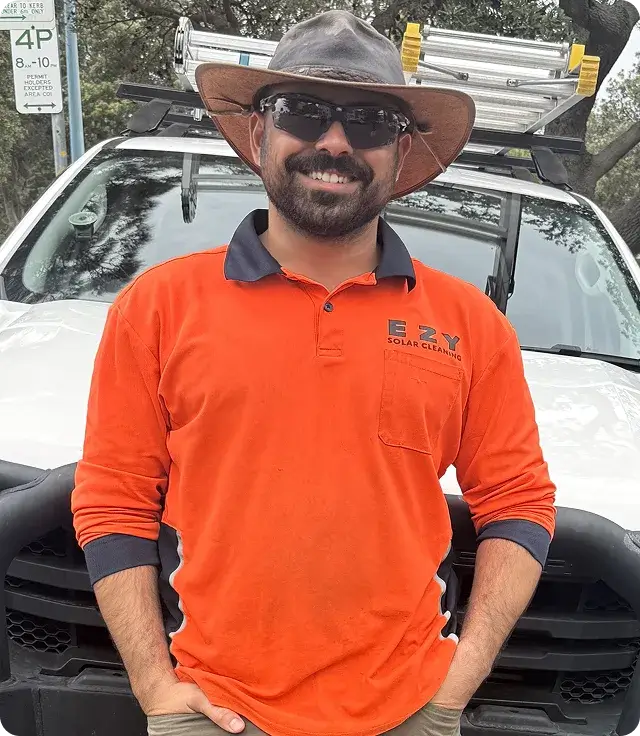 EZY Solar Cleaning team member standing in front of a service vehicle wearing company uniform